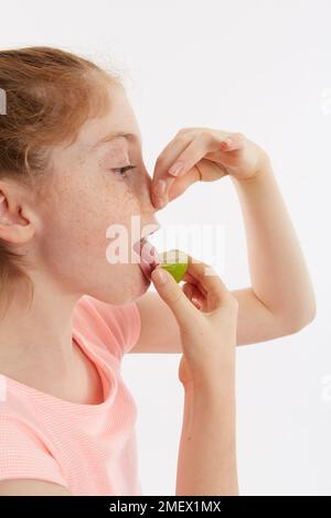 Cuneo di lime utilizzato per un test del gusto. Modello 10 anni. Foto Stock