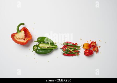 I bambini, con semi sparsi, tagliati aperti e disposti da miti a caldi; peperone, jalapeÒos, peperoncini, cobani scotch Foto Stock
