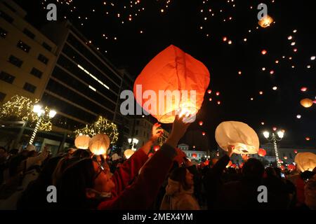 Le persone illuminano le lanterne del cielo durante la festa di Natale 'Notte di Wishes' fuori dal Municipio di Atene. Foto Stock