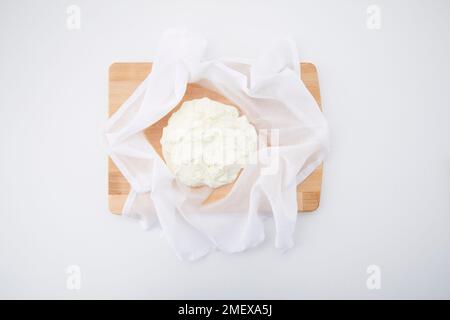 Preparazione Labneh - passaggio 1 - yogurt greco condito in un panno di formaggio sul tritare Foto Stock