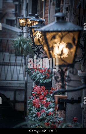 Una fila di lampade da parete per la strada su un canale a Venezia, Italia Foto Stock