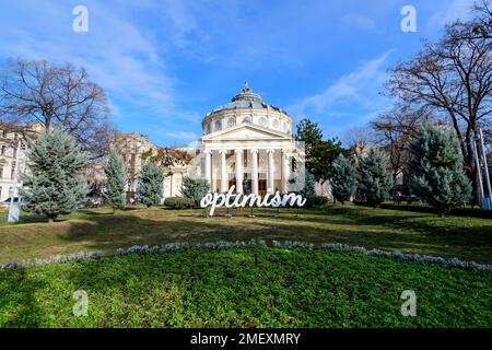 Bucarest, Romania, 2 gennaio 2022: Parola ottimista visualizzata di fronte al rumeno Atheneum Ateneul romano), edificio circolare che è la conce principale Foto Stock