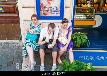 Madre con figlio e figlia che mangia gelato fuori gelateria a Roma Foto Stock