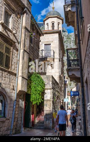 La strada stretta di Ulica 1 (istok-zapad), con il campanile della Chiesa di San Nicola (in alto) nella città vecchia di Cattaro in Montenegro Foto Stock