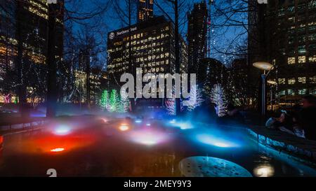 Fir fluorescenti e nebbia colorata al festival Winter Lights di Canary Wharf. Foto Stock