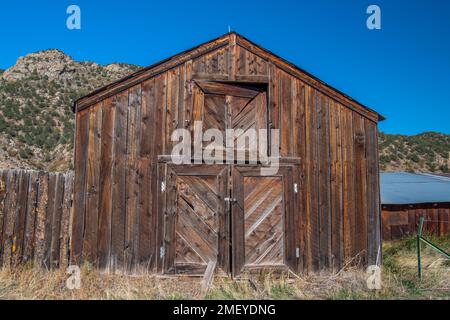 Ingresso a un vecchio fienile intempestivo vicino all'affascinante cittadina di Guffy, Colorado. Foto Stock