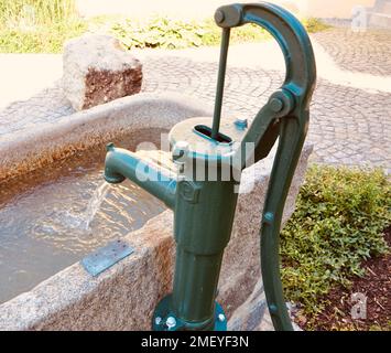 Vecchia pompa dell'acqua della mano nel giardino. Pompa dell'acqua in ghisa vintage Foto Stock