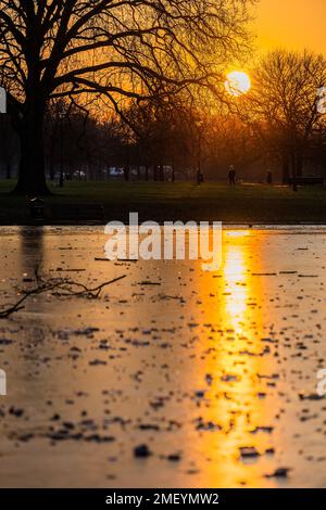 Londra, Regno Unito. 24th Jan, 2023. Il Sole si trova su un laghetto comune ghiacciato di Clapham. Le previsioni meteo suggeriscono che le temperature attuali possono sembrare miti rispetto al grande congelamento che si avvicina a febbraio. Credit: Guy Bell/Alamy Live News Foto Stock