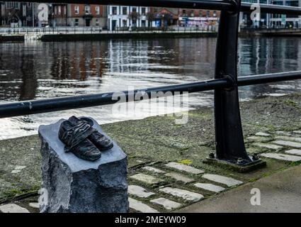 Un memoriale di scarpe sul Custom House Quay segna la carestia Walk, un viaggio di 165km intrapreso da 1490 persone da Strokestown a Dublino nel 1847. Foto Stock