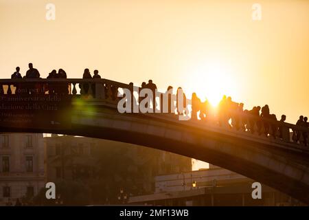 Sagoma di persone in piedi sul Ponte degli Scalzi sul Canal grande in prima serata con il sole sullo sfondo, Venezia, Italia. Foto Stock