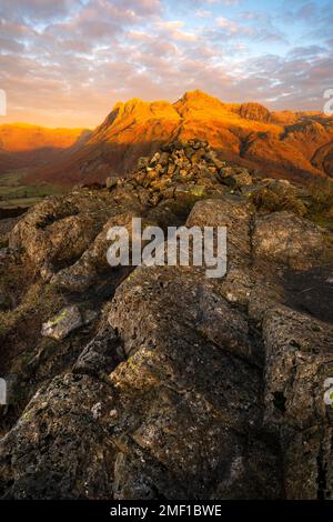 Luce dorata all'alba che illumina le cime delle pike di Langdale nel Lake District, Regno Unito. Foto Stock