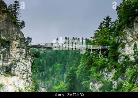 Foto del ponte di Marien vicino al Castello di Neuschwanstein durante il giorno dal basso Foto Stock