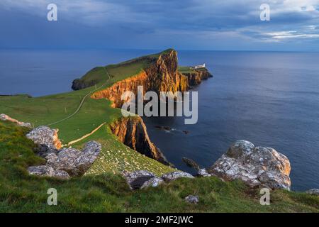 Il faro di Neist Point è immerso nella luce dorata in una splendida serata estiva. Isola di Skye, Scozia, Regno Unito. Foto Stock