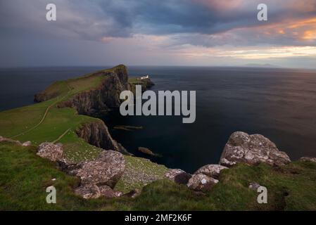 Nuvole drammatiche sopra il faro di Neist Point sull'isola di Skye, Scozia, Regno Unito. Foto Stock