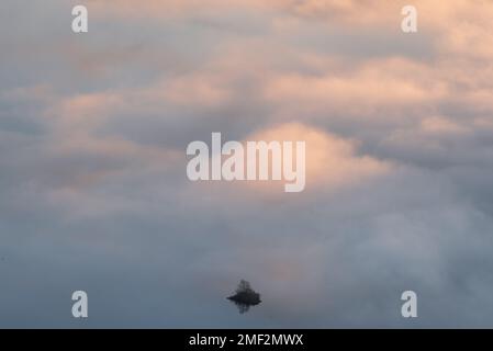 Piccola isola su un lago isolato contro un'inversione di nube da sogno a Derwentwater nel Lake District, Regno Unito. Paesaggi minimalisti della Gran Bretagna. Foto Stock