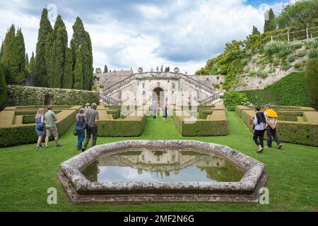 Persone che camminano attraverso i giardini in stile rinascimentale della tenuta la Foce, una storica residenza italiana toscana rivivuta da Antonino e Iris Origo. Foto Stock