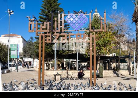 NAZARET, ISRAELE. Dicembre 27, 2022. Una piccola piazza nel centro di Nazareth sotto il cartello con il nome della città. Nazareth visite turistiche della vita editoriale Foto Stock