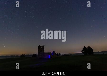 Chiesa di Knowlton, Nr Wimborne, Dorset UK. 24th gennaio 2023. Meteo UK: Stelle nel cielo notturno sopra la chiesa di Knowlton, una chiesa normanna costruita nel 12th ° secolo con terracotta neolitica intorno ad essa. Una notte limpida e fredda con temperature inferiori a zero. Credit: Carolyn Jenkins/Alamy Live News Foto Stock