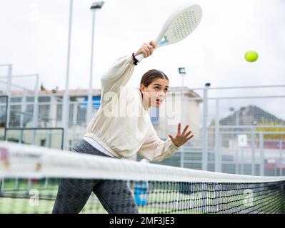 Giovane donna sportiva che gioca a paddle tennis all'aperto Foto Stock