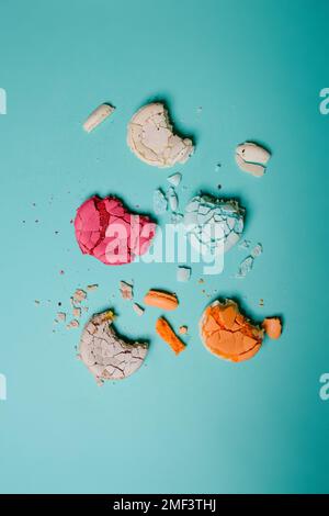 Macaron schiacciato, spezzato, dessert di colore francese su sfondo blu Foto Stock