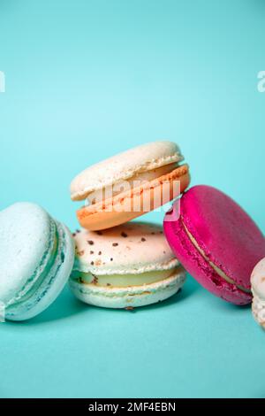 Macaron colorati. Piccoli dolci francesi. Amaretti francesi dolci e colorati su sfondo blu. Omaggio per San Valentino Foto Stock