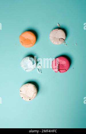 Macaron schiacciato, spezzato, dessert di colore francese su sfondo blu Foto Stock
