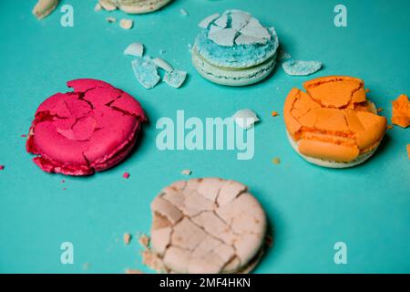 Macaron schiacciato, spezzato, dessert di colore francese su sfondo blu Foto Stock