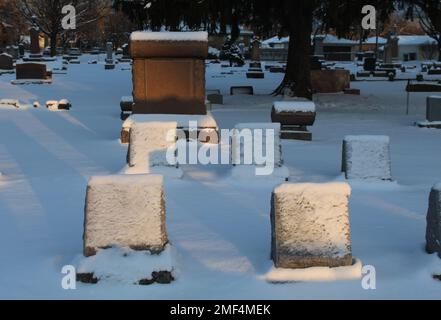 Lapidi ricoperte di neve in un piccolo cimitero suburbano di Chicago in inverno Foto Stock