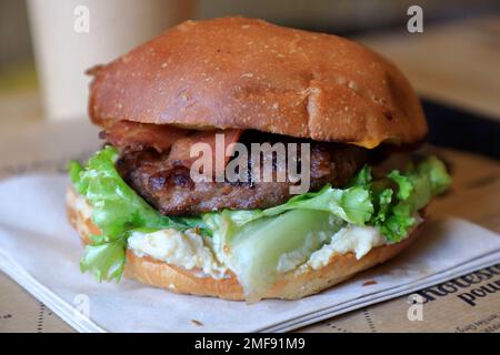 Una vista chiusa di un hamburger vegetariano sul tavolo di Hank Burger un ristorante vegan fast food a Parigi e Lione. Francia Foto Stock