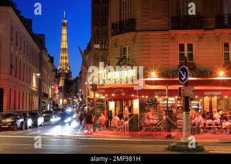 Vista notturna della Torre Eiffel e del Cafe le Recrutement, all'angolo tra Rue Saint-Dominique e Boulevard de la Tour-Maubourg, con veicoli al semaforo posteriore trails.Paris.France Foto Stock