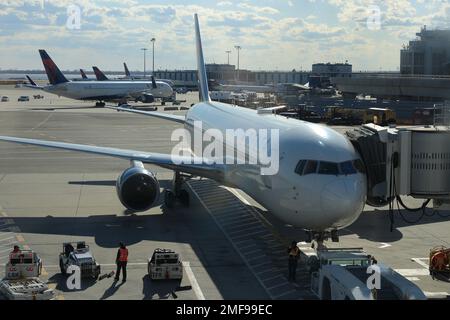 Un aereo passeggeri della Delta Air Lines collegato con un ponte jet nel terminal Delta dell'aeroporto JFK.New York City.NY. USA Foto Stock