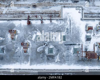 Foto aerea invernale del drone di un tetto su un camino industriale abbandonato di cemento fumo. Foto Stock