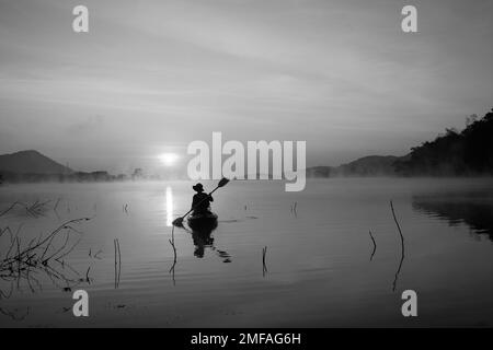 Donne in kayak file nel serbatoio durante l'alba, Harirak parco forestale Huai Nam Man Reservoir Loei Thailandia 21 gennaio 2023 Foto Stock