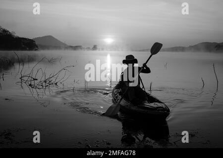 Donne in kayak file nel serbatoio durante l'alba, Harirak parco forestale Huai Nam Man Reservoir Loei Thailandia 21 gennaio 2023 Foto Stock