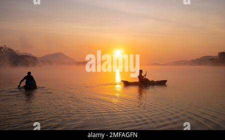 Donne in kayak file nel serbatoio durante l'alba, Harirak parco forestale Huai Nam Man Reservoir Loei Thailandia 21 gennaio 2023 Foto Stock