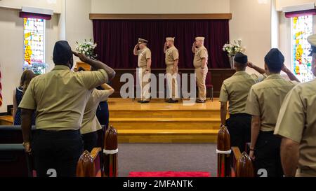 SASEBO, Giappone (18 agosto 2022) - i marinai salutano la firma durante l'inno nazionale durante la cerimonia del cambio di comando della contromisura della miniera Squadron (MCMRON) il 18 agosto 2022. MCMRON 7 conduce operazioni di contromisura integrate in miniera utilizzando risorse per lo smaltimento di ordigni esplosivi, in aria e in superficie, sia in situazioni di conflitto sia in situazioni di conflitto regionali negli Stati Uniti Settima area di responsabilità della flotta. Foto Stock