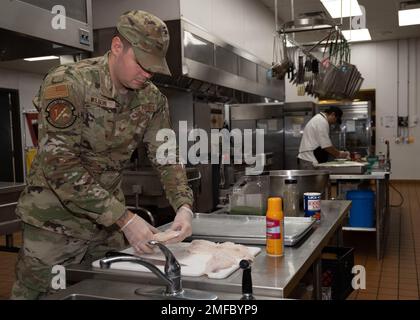 STATI UNITI Il personale dell'Aeronautica militare Sgt. Cody Wilson, 49th Force Support Squadron Dining Facility Shift leader, prepara il cibo per pranzo, il 19 agosto 2022 presso lo Shifting Sands Dining Facility, Holloman Air Force base, New Mexico. I lavoratori della struttura di Shifting Sands Dining Facility servono cibo agli Airmen e ai Guardiani durante tutto il giorno e la notte per garantire che siano sempre pronti per la missione. Foto Stock