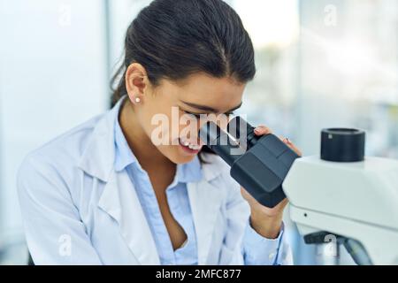 Anche i più piccoli dettagli sono di vitale importanza. un giovane scienziato che usa un microscopio in un laboratorio. Foto Stock