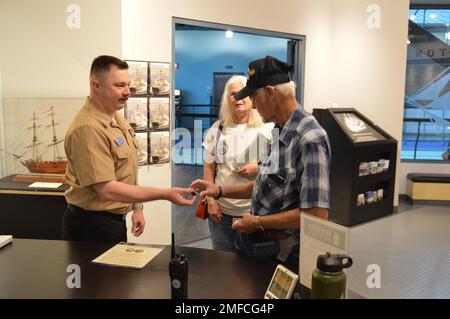 Il volontario attivo LS2(SW) Charles Fowler, assegnato alla USS Gerald R. Ford (CVN 78), presenta una spilla e una moneta commemorativa a Virgil Greene, che ha servito a bordo della USS Newport News (CA 148) come tecnico della caldaia di seconda Classe dal 1969-1973 durante la guerra del Vietnam. Greene stava visitando la mostra del Museo Navale di Hampton Roads, “la guerra dei dieci Mille giorni in mare: Gli Stati Uniti Navy in Vietnam, 1950-1975.” Il museo si trova al secondo piano dell'edificio Nauticus nel centro di Norfolk, Virginia Foto Stock