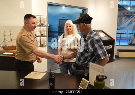 Il volontario attivo LS2(SW) Charles Fowler, assegnato alla USS Gerald R. Ford (CVN 78), presenta una spilla e una moneta commemorativa a Virgil Greene, che ha servito a bordo della USS Newport News (CA 148) come tecnico della caldaia di seconda Classe dal 1969-1973 durante la guerra del Vietnam. Greene stava visitando la mostra del Museo Navale di Hampton Roads, “la guerra dei dieci Mille giorni in mare: Gli Stati Uniti Navy in Vietnam, 1950-1975.” Il museo si trova al secondo piano dell'edificio Nauticus nel centro di Norfolk, Virginia Foto Stock