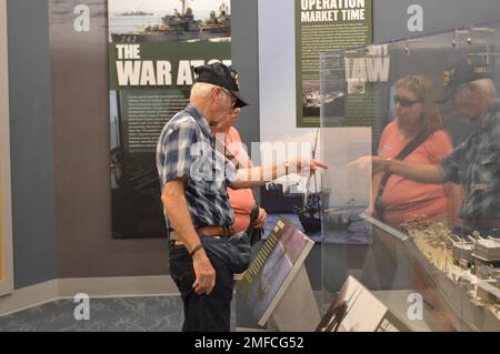 Virgil Greene, che ha servito a bordo della USS Newport News (CA 148) come tecnico della caldaia di seconda Classe, fornisce alcune informazioni riguardo al suo servizio durante una visita al Museo Navale di Hampton Roads. Greene ha servito a bordo di Newport News dal 1969-1973 durante la guerra del Vietnam, ed è raffigurato con un grande modello dell'incrociatore. Il grande modello di nave è in mostra al museo come parte della loro mostra “la guerra dei Temila giorni in mare: Gli Stati Uniti Navy in Vietnam, 1950-1975.” Il museo si trova al secondo piano dell'edificio Nauticus nel centro di Norfolk, Virginia. Foto Stock