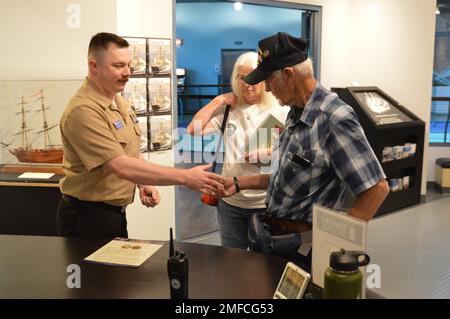 Il volontario attivo LS2(SW) Charles Fowler, assegnato alla USS Gerald R. Ford (CVN 78), presenta una spilla e una moneta commemorativa a Virgil Greene, che ha servito a bordo della USS Newport News (CA 148) come tecnico della caldaia di seconda Classe dal 1969-1973 durante la guerra del Vietnam. Greene stava visitando la mostra del Museo Navale di Hampton Roads, “la guerra dei dieci Mille giorni in mare: Gli Stati Uniti Navy in Vietnam, 1950-1975.” Il museo si trova al secondo piano dell'edificio Nauticus nel centro di Norfolk, Virginia Foto Stock