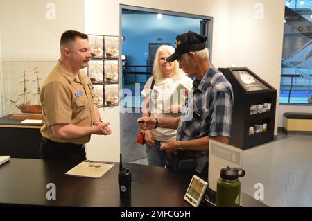 Il volontario attivo LS2(SW) Charles Fowler, assegnato alla USS Gerald R. Ford (CVN 78), presenta una spilla e una moneta commemorativa a Virgil Greene, che ha servito a bordo della USS Newport News (CA 148) come tecnico della caldaia di seconda Classe dal 1969-1973 durante la guerra del Vietnam. Greene stava visitando la mostra del Museo Navale di Hampton Roads, “la guerra dei dieci Mille giorni in mare: Gli Stati Uniti Navy in Vietnam, 1950-1975.” Il museo si trova al secondo piano dell'edificio Nauticus nel centro di Norfolk, Virginia Foto Stock