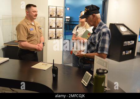 Il volontario attivo LS2(SW) Charles Fowler, assegnato alla USS Gerald R. Ford (CVN 78), presenta una spilla e una moneta commemorativa a Virgil Greene, che ha servito a bordo della USS Newport News (CA 148) come tecnico della caldaia di seconda Classe dal 1969-1973 durante la guerra del Vietnam. Greene stava visitando la mostra del Museo Navale di Hampton Roads, “la guerra dei dieci Mille giorni in mare: Gli Stati Uniti Navy in Vietnam, 1950-1975.” Il museo si trova al secondo piano dell'edificio Nauticus nel centro di Norfolk, Virginia Foto Stock