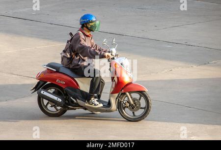 SAMUT PRAKAN, THAILANDIA, 23 2022 FEBBRAIO, Un uomo anziano con casco cavalca una moto Foto Stock