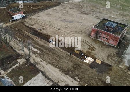 Workers wearing personal protective equipment bury bodies in a trench on Hart Island in the Bronx borough of New York on April 9, 2020. Hart Island is a strip of land in Long Island Sound that has long served as the city's potter's field. (AP Photo/John Minchillo)