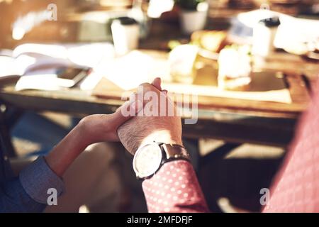 Pregando per il pasto e incontrarci stiamo per avere. dipendenti creativi che tengono le mani e pregano prima della colazione all'aperto. Foto Stock