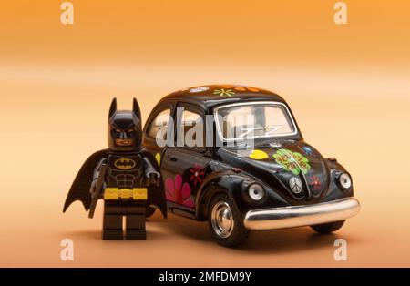 LEGO Batman pronto per la guida di un Beetle Volkswagen vintage dipinto nello stile di vita Hippie. Foto Stock