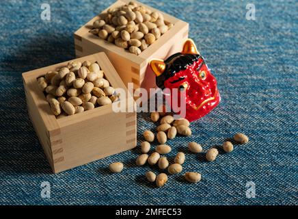 Fagioli per la lancio dei fagiolini e maschere di ogres poste su uno sfondo blu marino. Giapponese ogres. Imposta immagine secondaria. Foto Stock