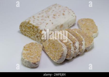 Tempe o tempeh è un cibo tradizionale indonesiano fatto di semi di soia fermentati. Sfondo bianco isolato Foto Stock